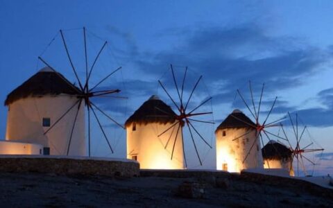 The windmills of mykonos, in greece, illuminated at night