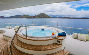 Jacuzzi on small ship Monique's Sky Deck nestled between padded lounging platforms before a wide-open view of the ocean in Galapagos