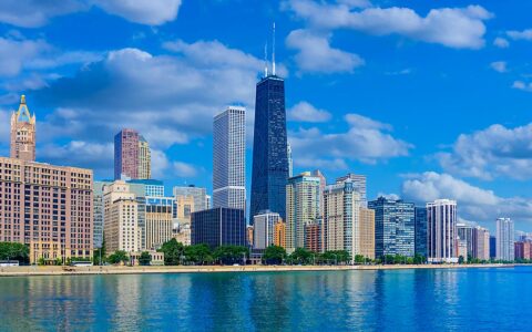 Downtown Chicago with tall dark Willis tower seen from the waterfront on a calm day during small ship great lakes cruises.