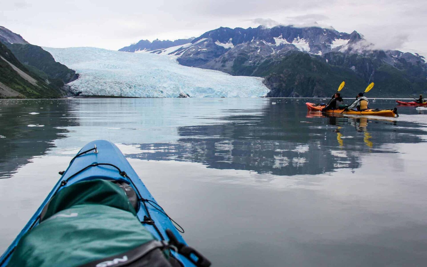 A few Alaska travelers kayaking in front of a glacier in Alaska.