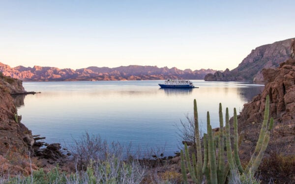 At a pastel sunset the Safari Voyager small ship anchors in a remote bay in Baja's Sea of Cortez surrounded by jagged mountains