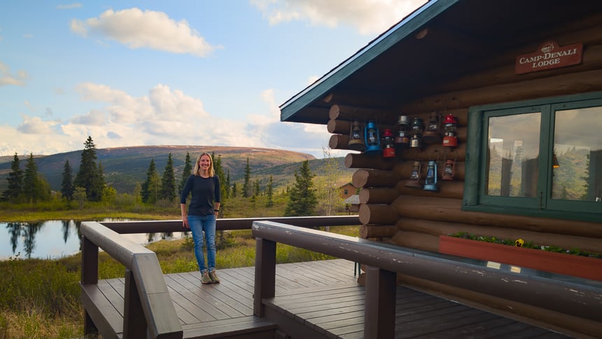 A woman stands on the deck of a Camp Denali cabin