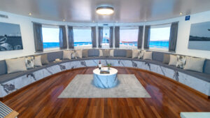 Lecture room with large wrap around bench couch aboard Galapagos Horizon ship.
