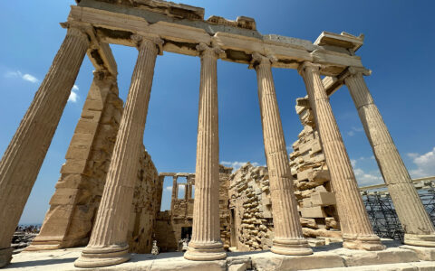 Ancient Greek ruins with beige columns holding crumbling stone, seen on the Greek Isles Odyssey cruise.