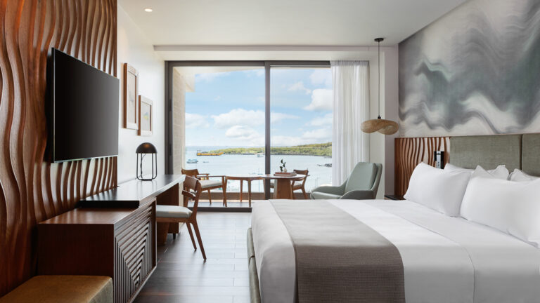 Standard hotel room at Hotel Indigo with king bed and sliding glass doors to a balcony