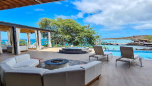 Outdoor lounge with comfortable seating at Hotel Indigo overlooking San Cristobal bay on a bright sunny day