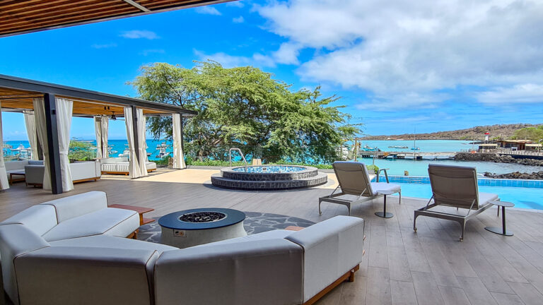 Outdoor lounge with comfortable seating at Hotel Indigo overlooking San Cristobal bay on a bright sunny day