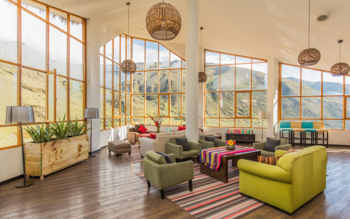 Lounge of Huacahuasi Lodge with breathtaking views through the large windows and an updated look