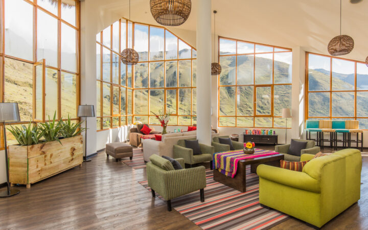 Lounge of Huacahuasi Lodge with breathtaking views through the large windows and an updated look