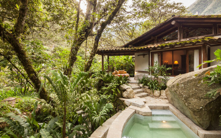 Hotel villa with large overhanging trees, stairs down to private pool, an outdoor