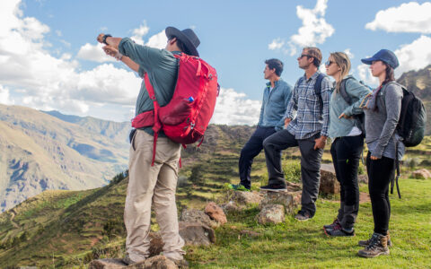 Hikers looking out into the views of machu picchu as the guide points out for all travelers