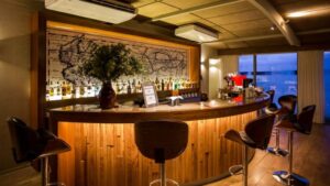 Stools surround a well-lit and well-stocked semicircle bar aboard Delfin III riverboat on Amazon River cruise