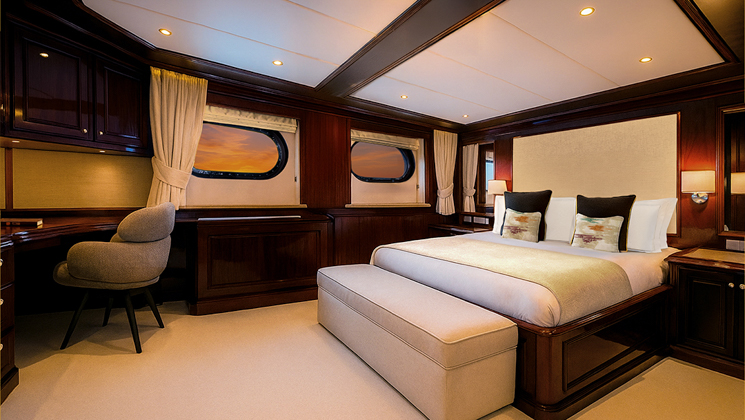 Suite #203 on Aqua Lares Africa superyacht with double bed, beige & dark wood accents, view windows, desk & soft lights.