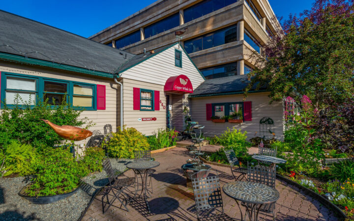 Exterior of Copper Whale Inn in Anchorage, Alaska with red sign with a painted copper whale