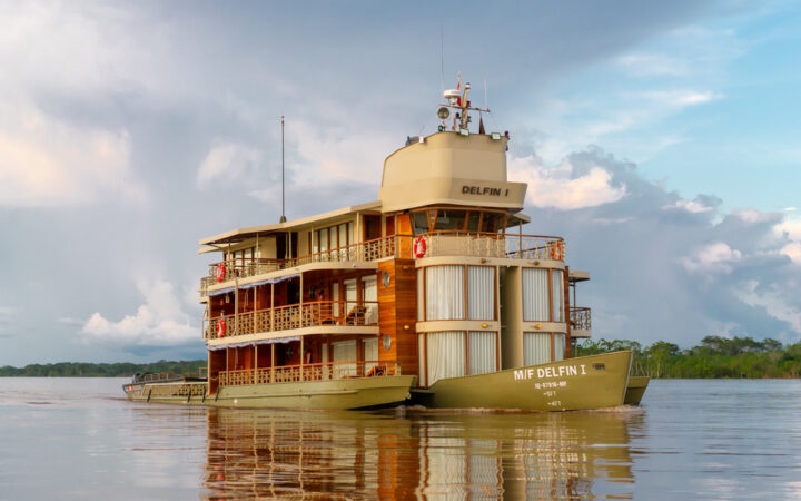 Exterior shot of Small river boat Delfin cruising through the amazon on a cloudy day