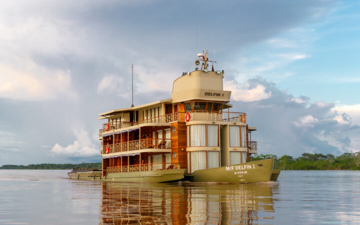 Exterior shot of Small river boat Delfin cruising through the amazon on a cloudy day