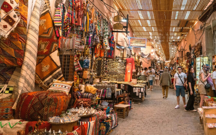 Colorful Moroccan street market with merchandise along both sides and shoppers roaming the market