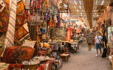 Colorful Moroccan street market with merchandise along both sides and shoppers roaming the market