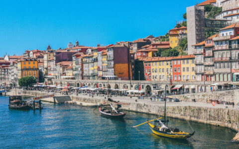 The bright and colorful port city with boats cruising along the icnoic landscapes on a sunny day