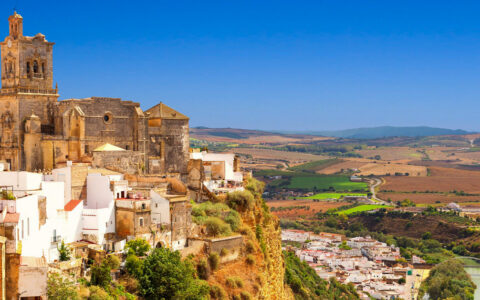 Historic city in Spain, with a church on the top of a large hill looking down on the valley below
