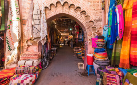 Moroccan market filled with color and stripped patterns and a beautiful arched stone walkway