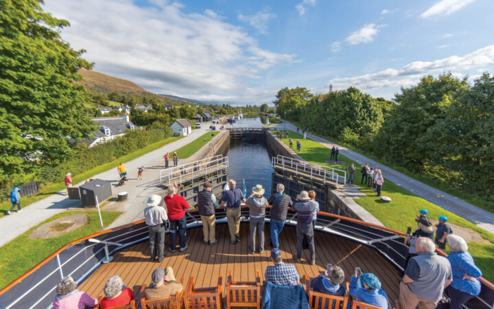 Guests watch on as Lord of the Glens transits the lock system on the Caledonian Canal, Scotland.