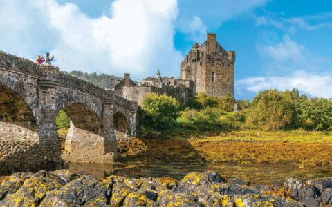 a stone castle in ireland with green landscape surrounding