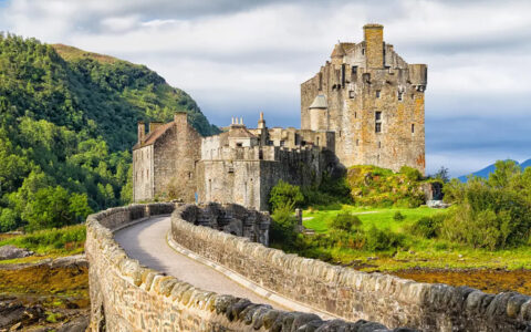 a stone castle in ireland with green landscape surrounding