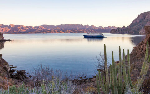 At a pastel sunset the Safari Voyager small ship anchors in a remote bay in Baja's Sea of Cortez surrounded by jagged mountains