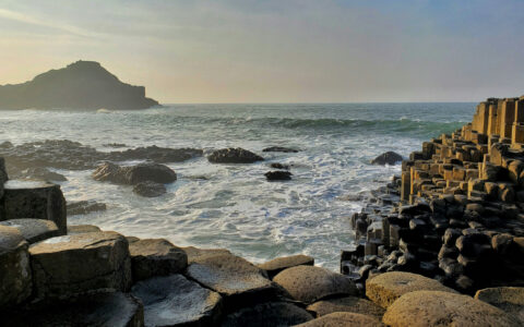 Large basalt columns make steps into the ocean at sunset, seen on a British Isles & France cruise.