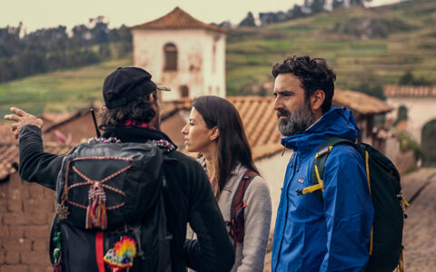 Explora Peru Sacred Valley travelers stand in a mountainside town listening to a guide explain their surroundings.