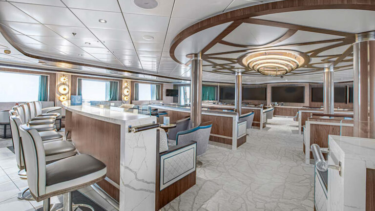 A modern, luxurious lounge on the Ocean Victory cruise ship with comfortable seating, a bar, and large windows.