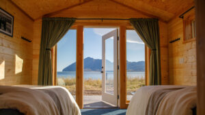 View looking out of the Bear Camp Alaska cabin with large windows and glass pain door