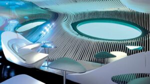 Blue Eye underwater lounge on Le Dumont D'Urville French ship, with wave-like designs, white leather rounded sofas, whale's eye windows & small tables, all in blue & turquoise colors.