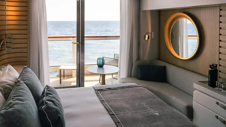 Prestige Stateroom - Decks 4, 5 & 6 aboard French expedition ship Le Jacques Cartier, with king bed, white linens, chic ethnic decor & private balcony.