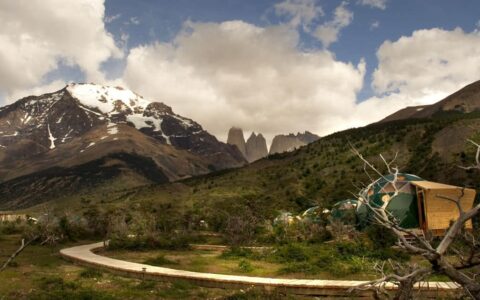 Boardwalk path to several glamping domes at the Patagonia Eco camp surrounded by mountains in chile
