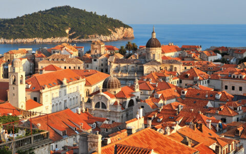 Aerial view of Dubrovnik, Croatia with its red-tiled roofs, stone buildinga, domes & seaside setting on a sunny day.
