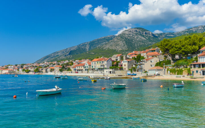 Seaside town of Brac with small fishing boats, white-sand beach & terra cotta-roofed homes, seen during the Best of Croatia luxury cruise.