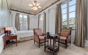 Balcony Junior Suite at Casa Gangotena. Stone columns line the windows from floor to ceiling. Seating arrangement in the foreground