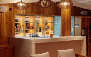 Bar shown with 2 cocktails on a Moscow mule on the counter aboard the small cruise ship, Evolution. Modern lighting, as well as a varied selection of alcohol.