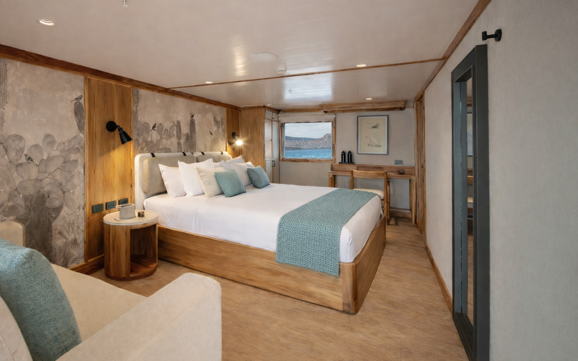 Small ship Evolution's sizable Master Suite with a king bed, armchair, and closet. Desk, a body-length mirror, and a window.