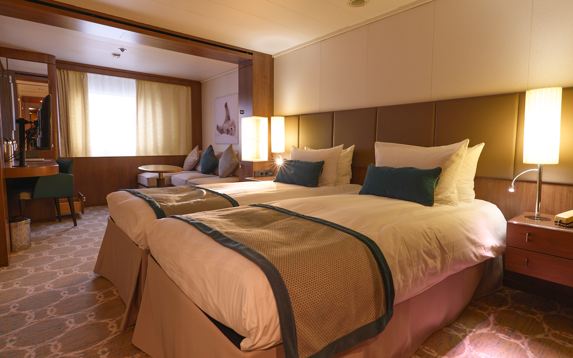 Deck 4 Superior cabin on Heritage Adventurer ship with 2 twin beds in white & brown linens, brown couch, green trim, desk & view window.