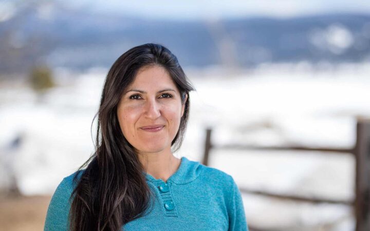 adventuresmith explorations adventure specialist leslie camacho smiling with a fence and snow in the background
