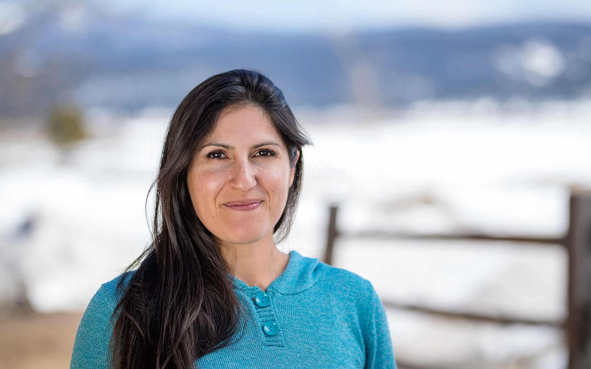 adventuresmith explorations adventure specialist leslie camacho smiling with a fence and snow in the background