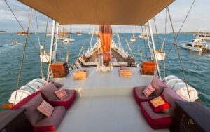 Top deck aboard the Katharina small cruise sailboat with red accented couches and lounge chairs.
