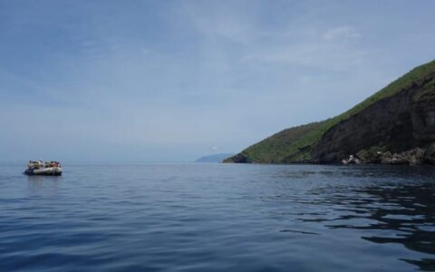 a zodiac boat from the beluga luxury cruise ship floats in the calm ocean waters at the galapagos islands