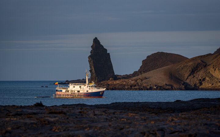 Cachalote Explorer Galapagos Cruises sailing through the breathtaking landscapes of the Galapagos on a peaceful dusk evening