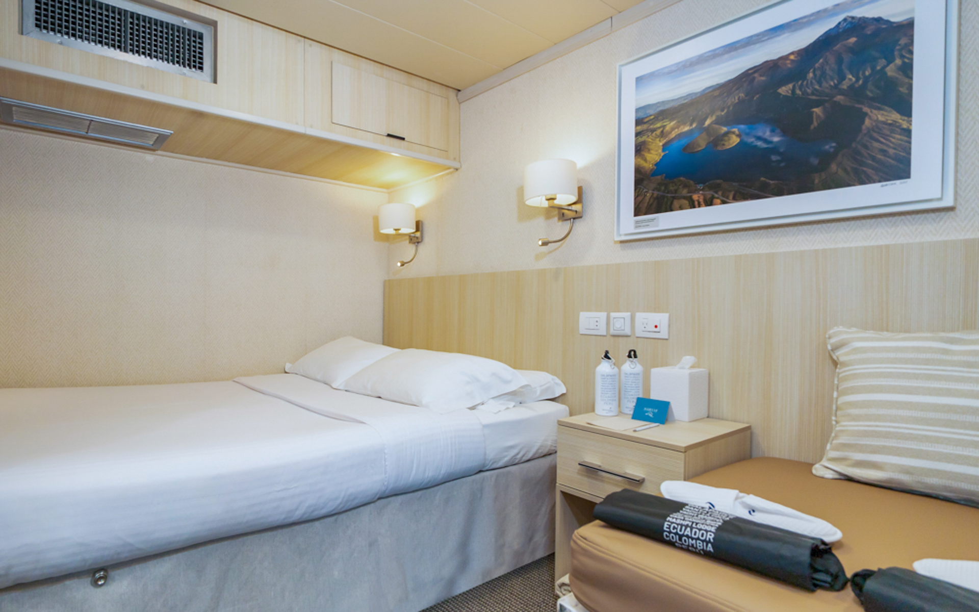 Small ship Isabela II Classic Family Cabin with double bed, fold out twin sofa, nightstand and double reading lights.