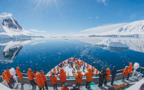Guests assembled on the balcony and bow of the ship on the National Geographic Antarctica, South Georgia and The Falklands cruise