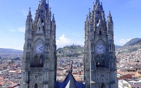 twin clock towers on a sunny day overlooking the city on the quito and guayaquil galapagos land tour